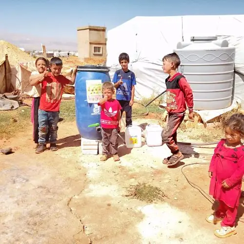 Children beside a HADUM collection unit in a community project